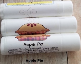 May include: Three white lip balm tubes with a red and brown apple pie design and the text "Apple Pie". The ingredients are listed on the bottom tube.