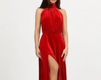 May include: A red velvet maxi dress with a high neck and a thigh-high slit. The dress has a fitted bodice and a flowing skirt.