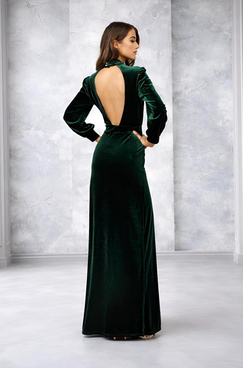 Emerald green velvet maxi dress with long sleeves, a low back, designed for formal occasions, weddings, or as a bridesmaid dress.