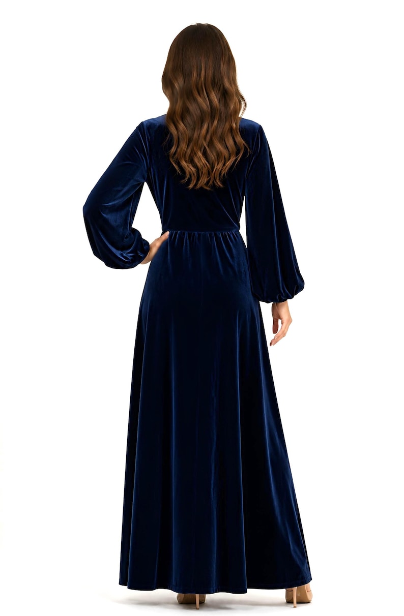 Navy blue velvet maxi dress with long loose sleeves. The dress features a fitted bodice and a flowing a line skirt.