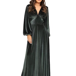 A long, dusty sage velvet dress with a V-neck and long sleeves. The dress features a fitted bodice and a flowing skirt. The sleeves are gathered at the wrist. The floor-length dress is made of a soft, luxurious fabric.