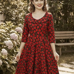 May include: A red floral print dress with a scoop neckline and three-quarter sleeves. The dress has a full skirt and is worn with a matching headband. The background shows a garden with flowers and a wooden bench.