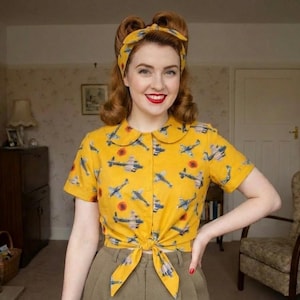 Könnte beinhalten: Ein gelbes kurzärmeliges Hemd mit Bindeband, das mit Flugzeugen und roten Sonnen gemustert ist. Dazu eine olivgrüne Hose und ein passendes gelbes Stirnband. Der Look hat einen Vintage-Stil.