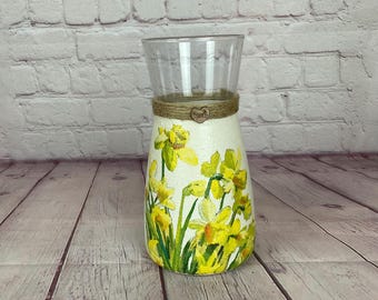Blomvas med gula påskliljor och gröna stjälkar decoupagede på målad glasvas. Med snöredetaljer kan den göras personlig som present.