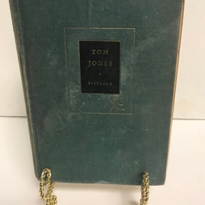 May include: A green hardcover book with the title "TOM JONES" by FIELDING on the spine.