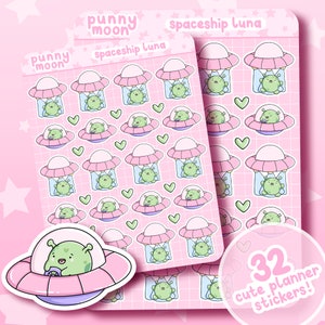 May include: A sheet of 32 pink and white planner stickers featuring cute green aliens in pink spaceships. The text "punny moon" and "spaceship luna" is printed on the sheet.