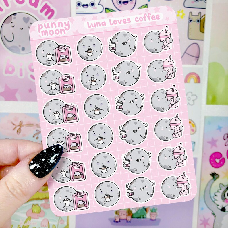 Op de afbeelding: Een vel roze stickers met een cartoon maan die een kopje koffie en een koffiezetapparaat vasthoudt. De stickers zijn in een rasterpatroon gerangschikt en bovenaan staat "Luna Loves Coffee".