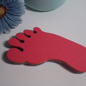 May include: A stack of colorful foam foot prints in red, orange, yellow, green, blue, and purple.