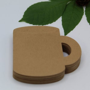 May include: A stack of brown paper coffee cup cutouts. The cups have a handle and are perfect for crafting or party decorations.