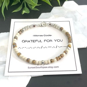 May include: A beaded bracelet featuring alternating matte cream and metallic brown beads with silver accents. The bracelet is displayed on a white card printed with the text Morse Code, GRATEFUL FOR YOU, the corresponding code, and the URL SunsetSouthpaw.etsy.com.