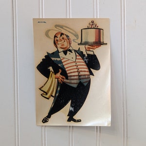 May include: A vintage postcard featuring a cartoon waiter in a tuxedo holding a plate with a cake on it. The waiter is smiling and has a red, white, and blue striped vest. The cake is white with a red and white filling and a single lit candle on top.