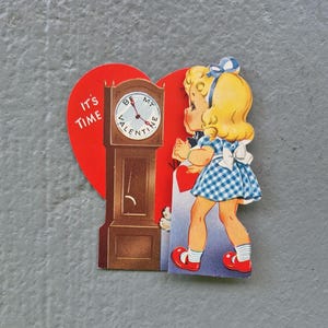 May include: Vintage Valentine's Day card featuring a young girl in a blue and white checkered dress and red shoes. The card has a red heart shape with a grandfather clock and the text "It's Time" and "Be My Valentine".