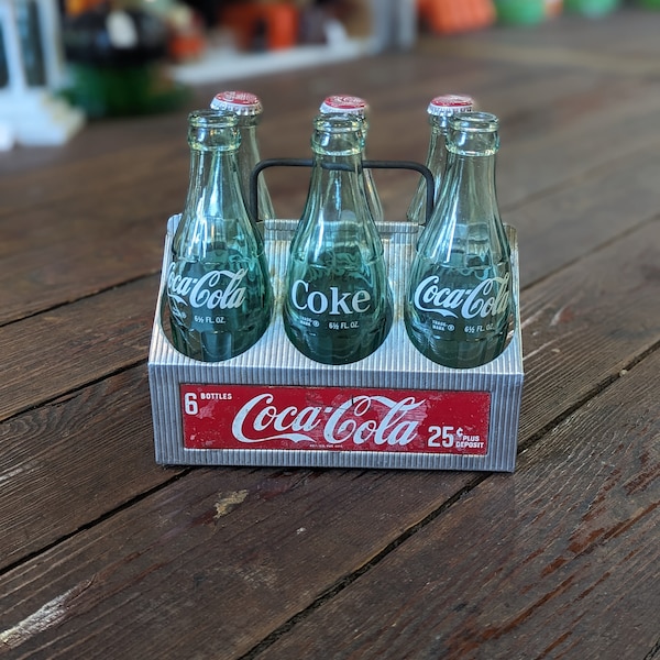 Vintage metalen Coca-Cola-draagtas en zes diverse flessen