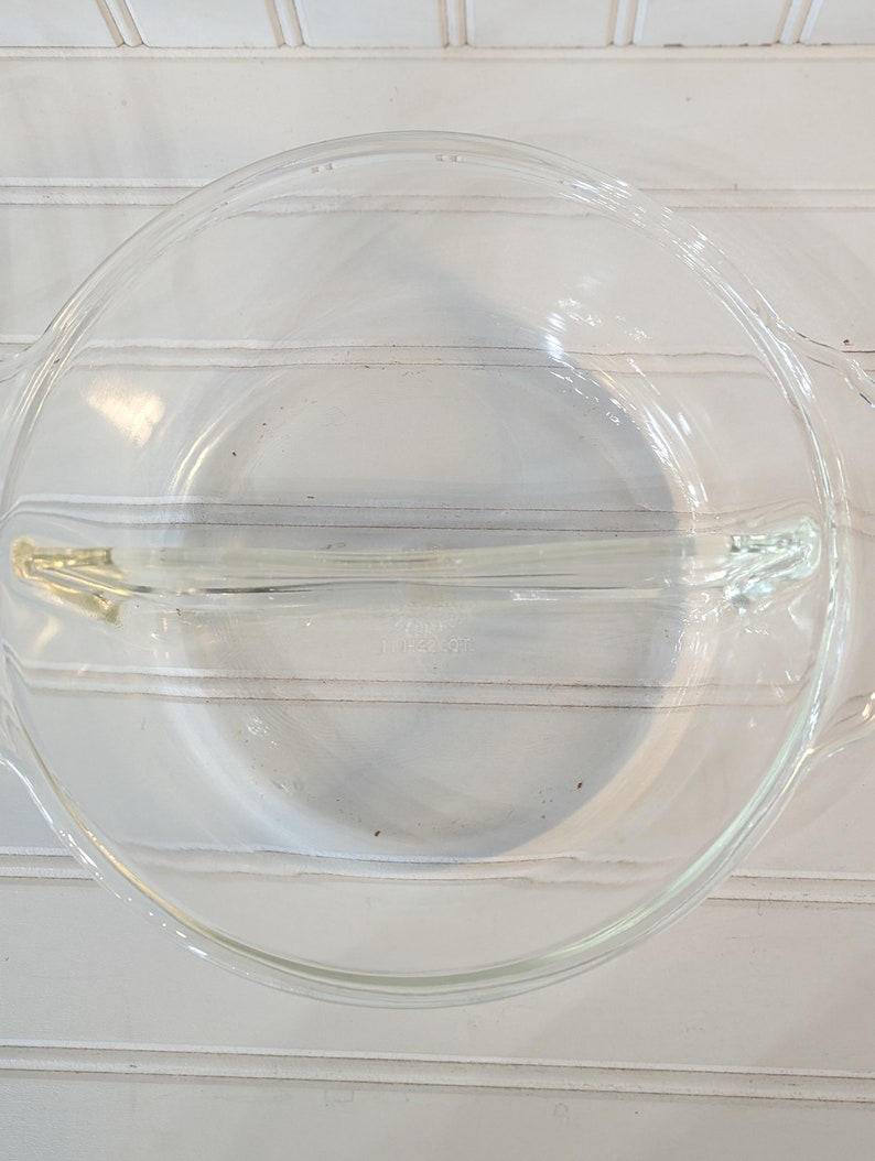 May include: A clear glass pie plate with a divider in the middle. The plate is designed for making two different pies or desserts.