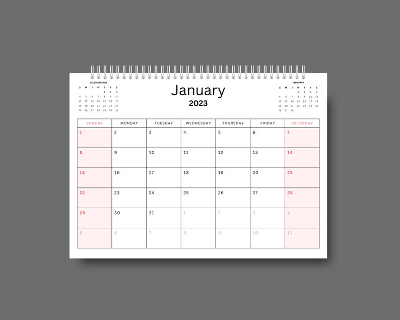 May include: A white calendar with a black spiral binding. The calendar is for January 2023 and has the days of the week labeled at the top. The numbers for each day are in red.