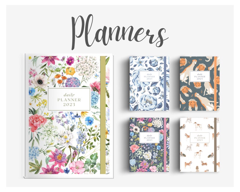 May include: Four different daily planners with floral and animal print designs. The planners are all the same size and have a gold or brown ribbon bookmark. The text on the planners reads "daily planner 2023".