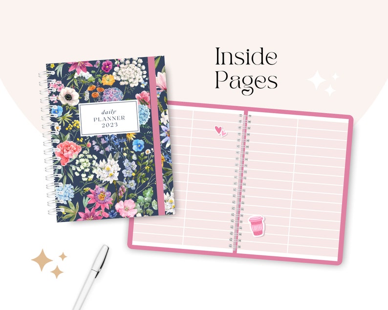 May include: A daily planner with a floral design on the cover. The inside pages are pink with lines for writing. The planner has a pink binding and a silver pen is next to it.