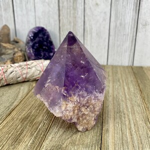 K&ouml;nnte beinhalten: Eine gro&szlig;e, violette Amethyst-Kristallspitze mit einer nat&uuml;rlichen, rauen Basis. Der Kristall ist klar und hat einen leichten Schimmer. Es ist ein wundersch&ouml;nes Beispiel f&uuml;r einen nat&uuml;rlichen Amethyst-Kristall.