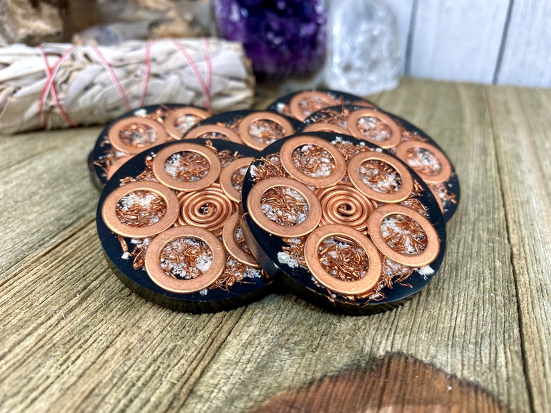 Peut inclure: Six sous-verres en r&eacute;sine noire avec du fil de cuivre et des paillettes blanches incrust&eacute;s dans la r&eacute;sine. Chaque sous-verre pr&eacute;sente un motif circulaire avec une spirale de fil de cuivre au centre.