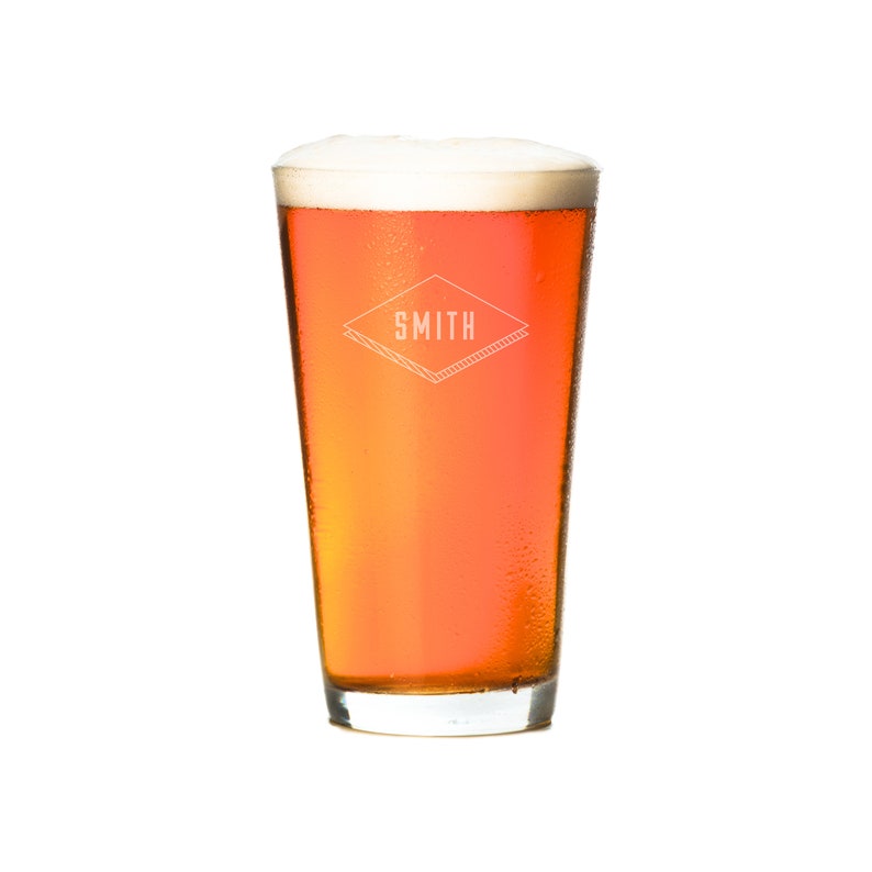 Puede incluir: Un vaso alto de cerveza &aacute;mbar con una cabeza blanca. El vaso tiene un logotipo que dice "SMITH" en forma de diamante.