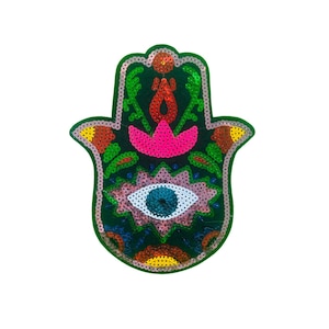 以下が含まれることがあります： 青い目、ピンクの花、赤と黄色のアクセントが付いた緑色のハmsaの手。ハmsaの手はスパンコールでできており、保護と幸運の一般的なシンボルです。
