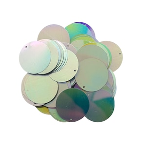 May include: A pile of iridescent, round sequins. Each sequin has a small hole near the edge. The sequins reflect a range of colors, including green, blue, and purple, against a white background. These craft supplies are ideal for embellishments.