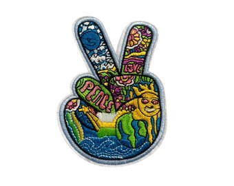Könnte beinhalten: Ein bunter gestickter Peace-Zeichen-Patch mit einem blauen, grünen und gelben Erddesign, einer Sonne mit einem lächelnden Gesicht und dem Wort "peace" in Rosa.
