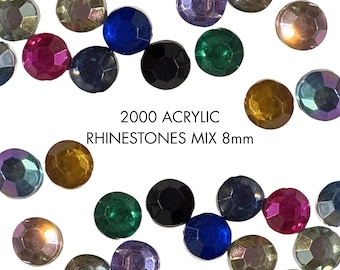 Könnte beinhalten: Eine Sammlung von 2000 runden Acryl-Strasssteinen in verschiedenen Farben wie Blau, Grün, Pink, Schwarz und Gold. Jeder einzelne Strassstein hat einen Durchmesser von 8 mm und eine facettierte Oberfläche. Der Text 2000 ACRYLIC RHINESTONES MIX 8mm ist mittig aufgedruckt.
