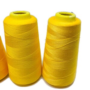 May include: Three spools of bright yellow thread.