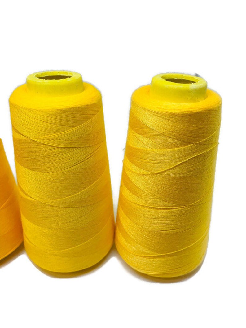 May include: Three spools of bright yellow thread.