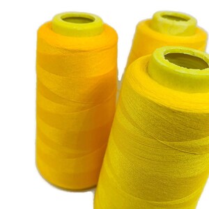 May include: Three spools of bright yellow thread.