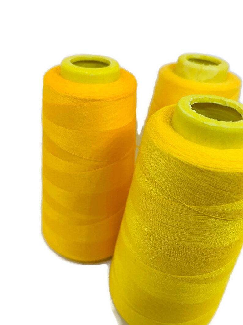 May include: Three spools of bright yellow thread.