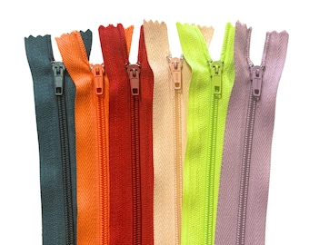 Könnte beinhalten: Eine Sammlung farbenfroher Reißverschlüsse in verschiedenen Farbtönen, darunter Teal, Orange, Rot, Beige, Limettengrün und Lavendel. Jeder Reißverschluss ist geschlossen und vertikal angeordnet.