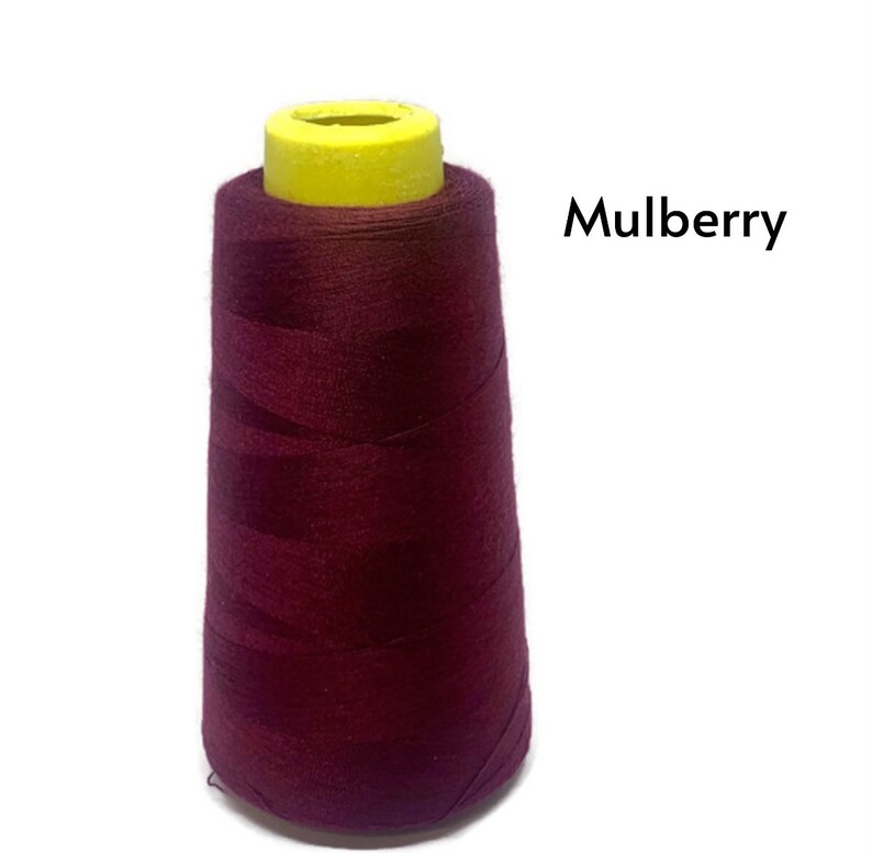 May include: A spool of maroon thread with a yellow plastic top. The text "Mulberry" is printed on a white background.