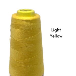 May include: A spool of light yellow thread.