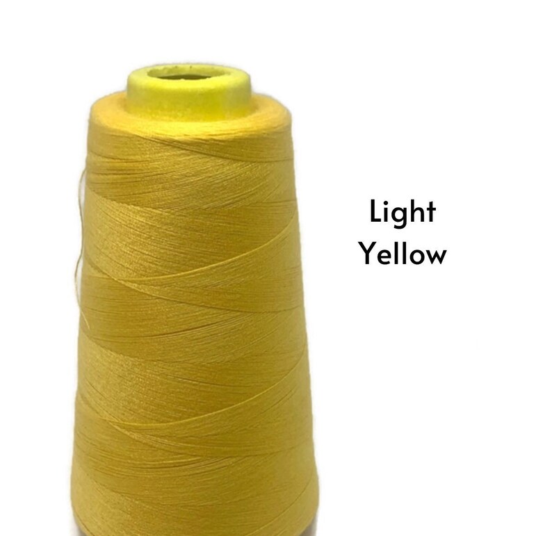 May include: A spool of light yellow thread.