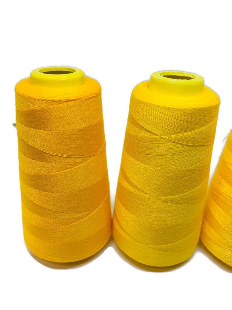 May include: Three spools of bright yellow thread.