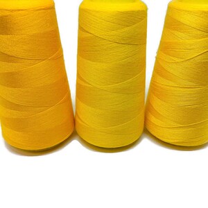 May include: Three spools of bright yellow thread.