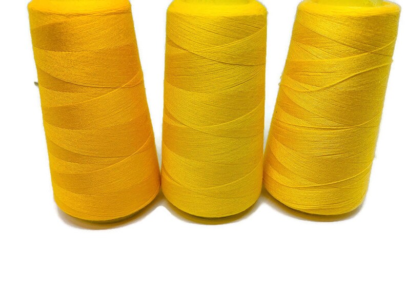May include: Three spools of bright yellow thread.