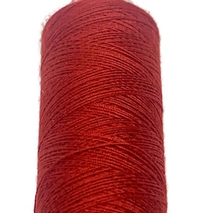 Puede incluir: Una bobina de hilo rojo.