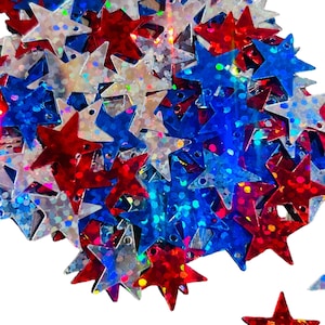 May include: A pile of red, white and blue glitter star-shaped sequins. The sequins are iridescent and have a holographic finish.