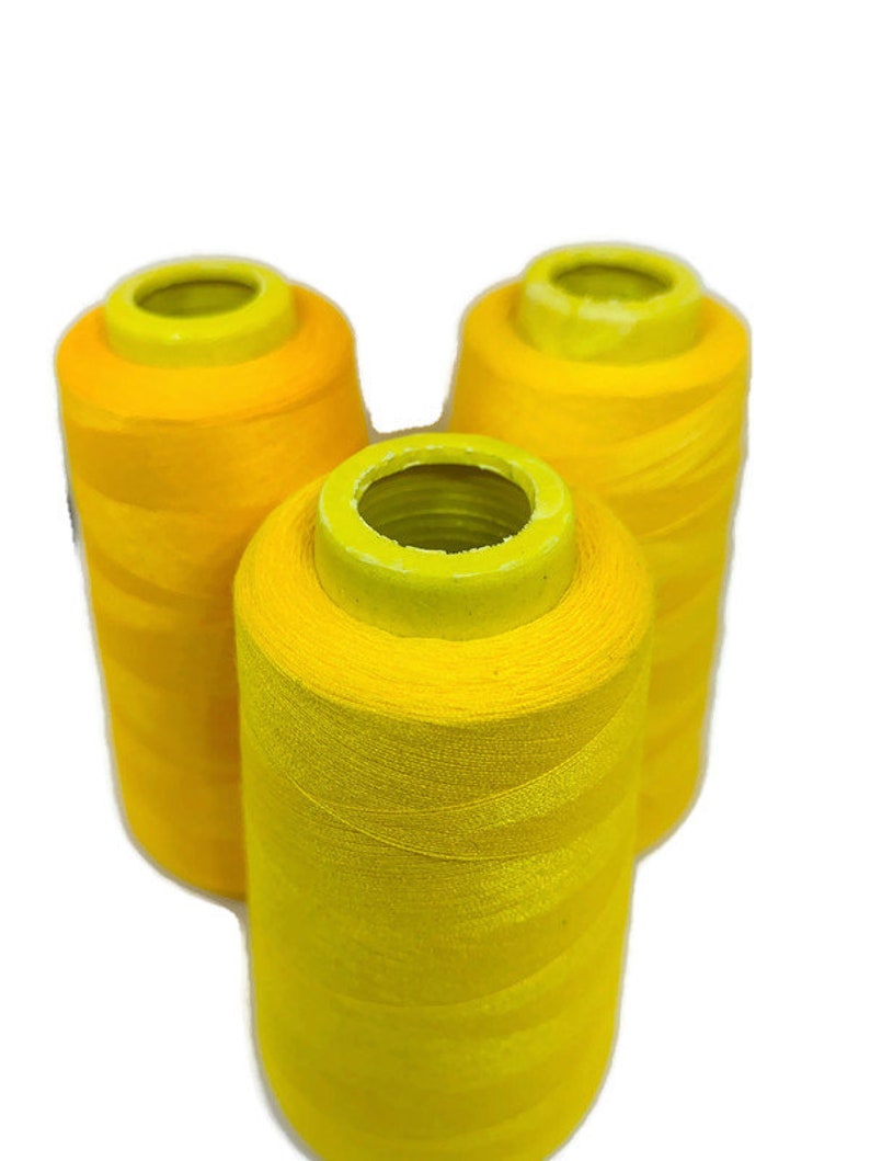 May include: Three spools of bright yellow thread.