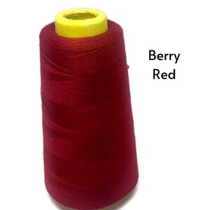 May include: A spool of red sewing thread with a yellow plastic top. The text "Berry Red" is visible in the image.