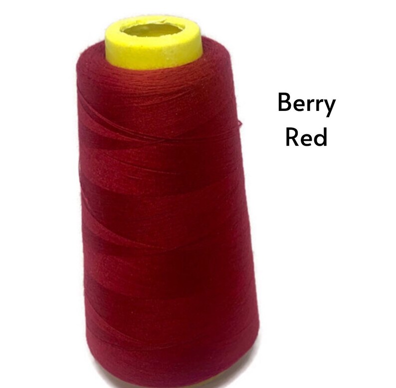 May include: A spool of red sewing thread with a yellow plastic top. The text "Berry Red" is visible in the image.