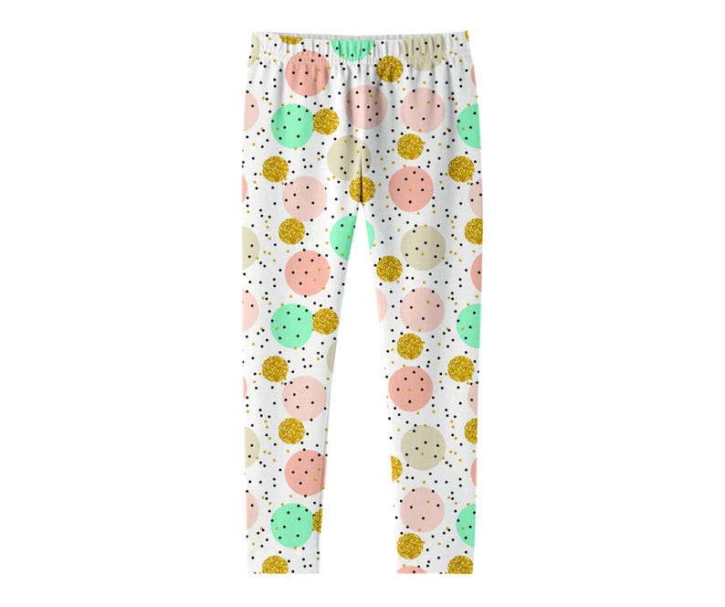 K&ouml;nnte beinhalten: Leggings mit wei&szlig;em Hintergrund und einem sich wiederholenden Muster aus Punkten in zartem Rosa, Mintgr&uuml;n, Beige und Goldglitzer. Das Design enth&auml;lt kleine schwarze Sprenkel, die &uuml;ber den Stoff verteilt sind und ein festliches, buntes Aussehen erzeugen.
