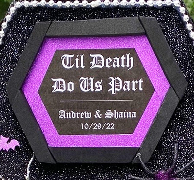 Puede incluir: Un letrero hexagonal negro con un fondo de purpurina morado y una inscripci&oacute;n blanca que dice "Til Death Do Us Part" con los nombres "Andrew & Shaina" y la fecha "10/29/22" debajo.