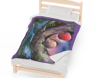 May include: A purple and grey throw blanket featuring a colourful painting of a forest scene with a red and white moon. The painting is surrounded by a purple border.