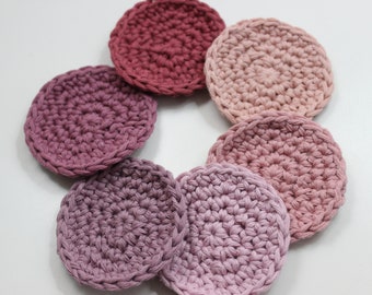 May include: Set of seven crocheted cotton rounds in shades of pink and red. The rounds are arranged in a circle, with the darkest shade in the center and the lightest shade on the outside.