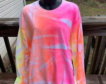 May include: A long-sleeved shirt with a tie-dye pattern in shades of pink, orange, and yellow.