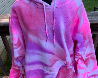 May include: A pink, purple, and white tie-dye hoodie with a drawstring hood.